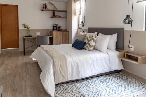 a bedroom with a large white bed and a desk at Lope 226, Polanco in Mexico City