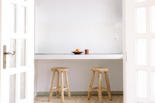 a kitchen with two wooden stools in front of a counter at Kaminia Holiday Homes in Éxo Goniá