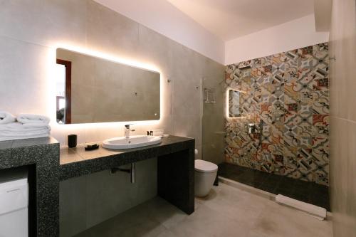 a bathroom with a sink and a mosaic wall at Kaminia Holiday Homes in Éxo Goniá