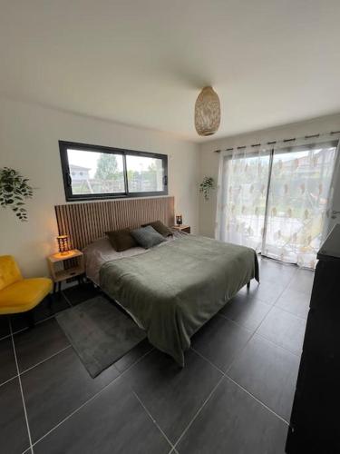 une chambre avec un grand lit et une fenêtre dans l'établissement Villa moderne avec piscine, à Saint-Aubin-de-Médoc
