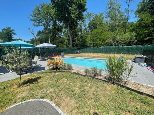une piscine dans une cour clôturée dans l'établissement Villa moderne avec piscine, à Saint-Aubin-de-Médoc