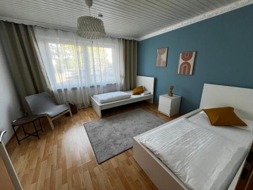 a bedroom with blue walls and a bed and a window at TOP Anbindung Nähe Hannover 2Min Lehrte BHF Check in bis 0 UHR - SELF Check in! in Lehrte