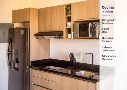 a kitchen with a stainless steel refrigerator and a microwave at Marina Cerritos Loft Wave Pool and Amenities in Mazatlán