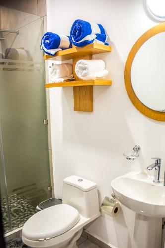 a bathroom with a toilet and a sink and a mirror at Marina Cerritos Loft Wave Pool and Amenities in Mazatlán