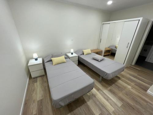 a room with two beds and a mirror at O Prior - Aposentos in Urzelina