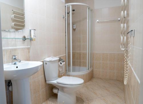La salle de bains est pourvue de toilettes, d'un lavabo et d'une douche. dans l'établissement Hotel Wilanów, à Varsovie