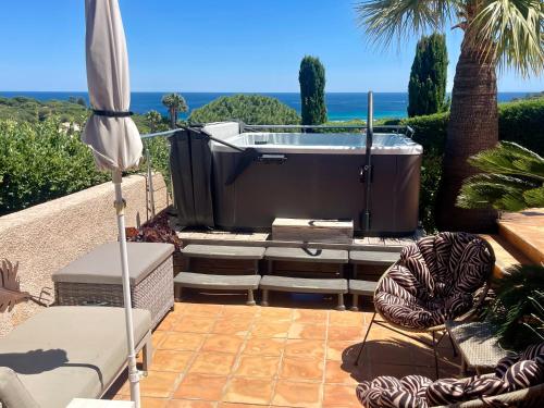 a hot tub on a patio with a palm tree at Villa Riviera, Sea view, Pool, Jacuzzi, Sauna, Walk to the beach in Sainte-Maxime