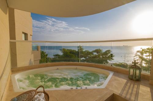 a jacuzzi tub in a building with an ocean view at Irotama Reservado Apartamento frente al mar in Santa Marta