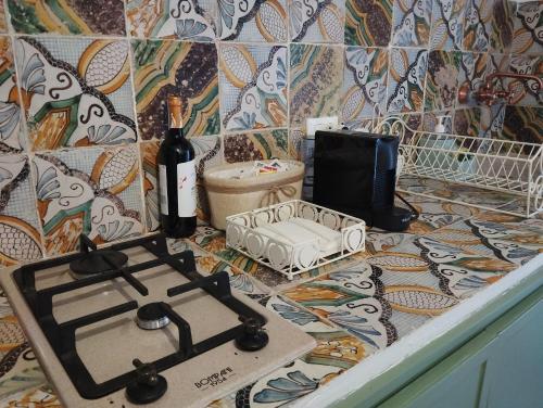 a kitchen counter with a stove and a bottle of wine at Erice Appartamenti in Erice