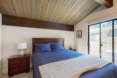 a bedroom with a blue bed with a wooden ceiling at Forest Pines Condo 1 - 46 in Incline Village