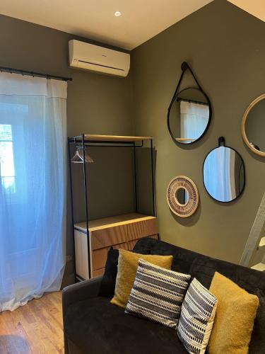 - un salon avec un canapé et des miroirs sur le mur dans l'établissement Les Terrasses de Padoue, à Corte