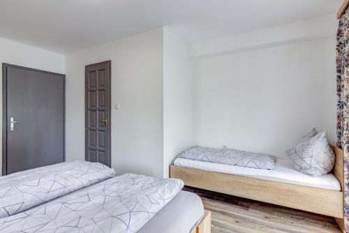two beds in a room with white walls at Ludwighaus in Neukirchen am Großvenediger