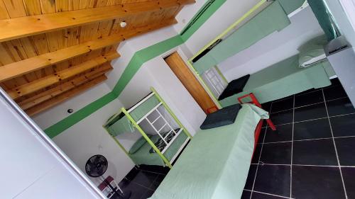 uma vista sobre um quarto com paredes verdes e tectos em madeira em Hostel Richieri em Neuquén