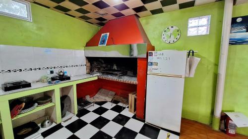 uma pequena cozinha com frigorífico e piso em xadrez em Hostel Richieri em Neuquén