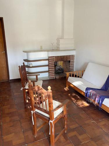ein Wohnzimmer mit einem Bett, Stühlen und einem Kamin in der Unterkunft Departamento España in Villa Mercedes