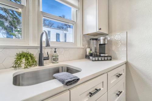 a kitchen with a sink and two windows at Pikes Adventure - Downtown King Scenic Views in Colorado Springs