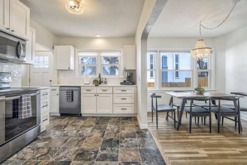 a kitchen with white cabinets and a table with chairs at Pikes Adventure - Downtown King Scenic Views in Colorado Springs