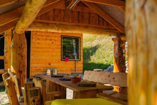 a wooden cabin with a table and chairs in it at Na samote u lesa in Revúca