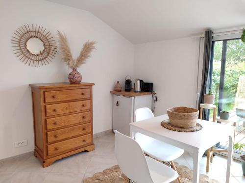 un comedor con una mesa blanca y un tocador en Studio au coeur de Guérande, en Guérande