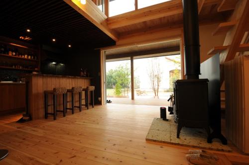 una sala de estar con estufa de leña. en 阿蘇熊本 木の香の家 OMOYA - Aso Kumamoto Airport Timber House "KONOKA NO IE OMOYA", en Nishiharamura