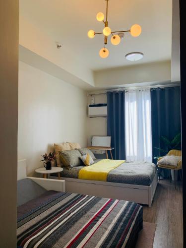 a bedroom with a bed and a chandelier at The Median studio unit near Cebu IT Park Lahug in Cebu City