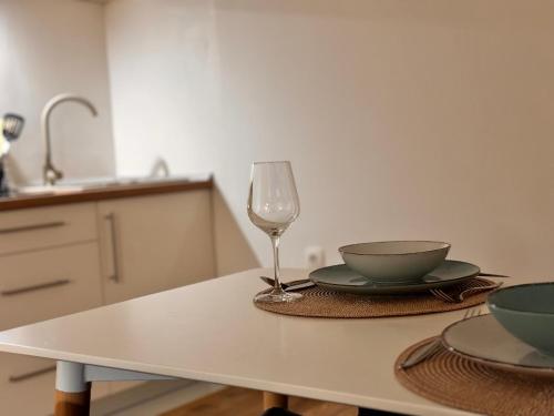 a table with a glass of wine and a bowl at Apartman AN12 in Neum