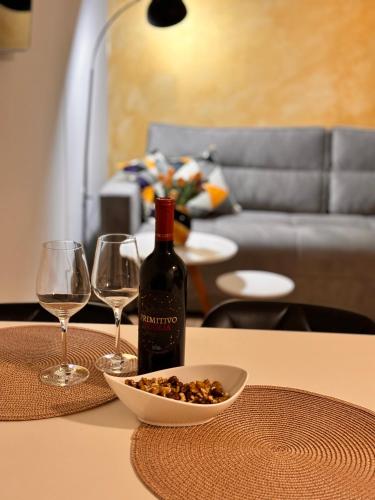 a bottle of wine sitting on a table with two glasses at Apartman AN12 in Neum