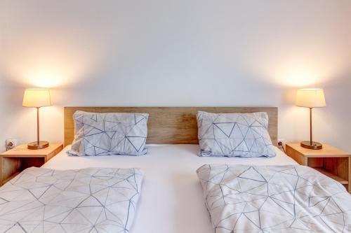 a bedroom with a bed with two lamps on both sides at Ludwighaus in Neukirchen am Großvenediger