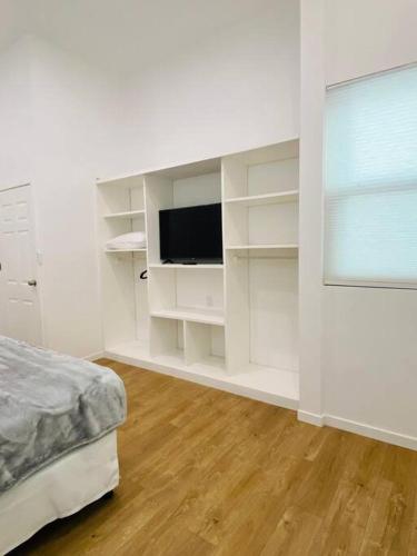 a white room with a bed and a television at Casa Victoria in Flores