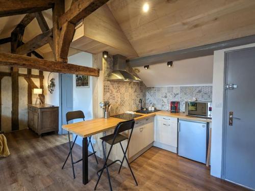 une cuisine avec une table et des chaises dans une pièce dans l'établissement Au berceau de Troyes, à Troyes