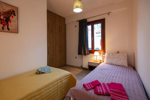 Un dormitorio con dos camas y una ventana. en Giorgia's home, en Kokkari