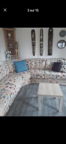 un salon avec un canapé et une table dans l'établissement Coin de paradis idéal nature, à Houlle