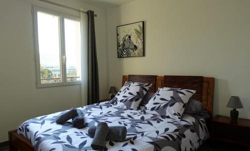 une chambre avec un lit avec des oreillers et une fenêtre dans l'établissement T2 40m2 Ollioules, la nature, à 10 mins des plages, à Ollioules