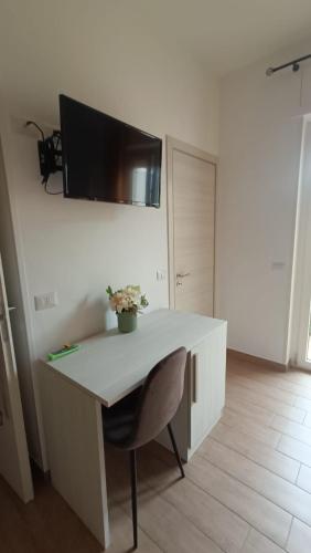 a white desk with a chair and a tv on a wall at Mar Art Sapri in Sapri