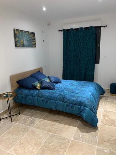 - un lit avec une couette bleue dans une chambre dans l'établissement Bas de villa avec piscine privée, aux Pennes-Mirabeau