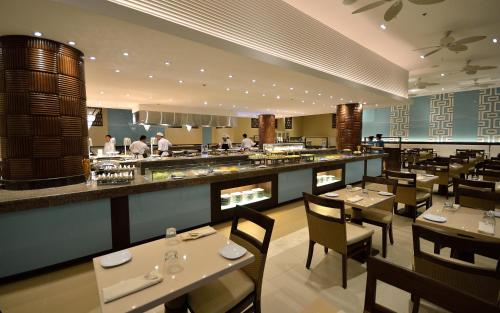 a restaurant with tables and chairs and a bar at Henann Resort Alona Beach in Panglao