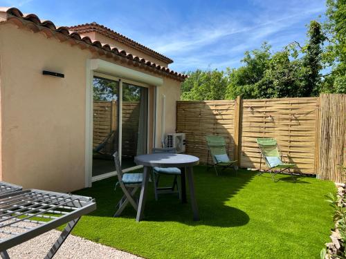 une cour avec une table, des chaises et une clôture dans l'établissement Bienvenue chez vous, à Saint-Cézaire-sur-Siagne