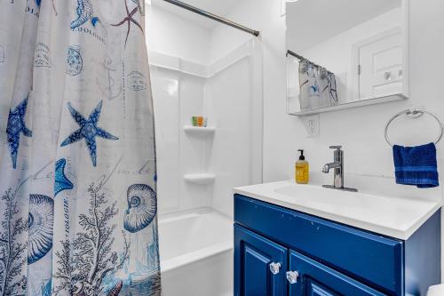 a bathroom with a blue sink and a shower curtain at Highly Rated Beach House - 6 Badges, Outdoor Patio, Grill - 3 Blocks to Beach & Boards in Belmar