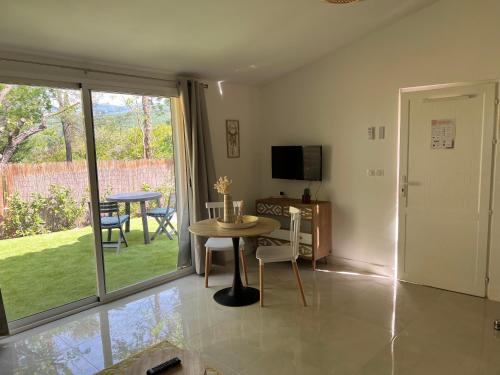 un salon avec une table et une télévision dans l'établissement Bienvenue chez vous, à Saint-Cézaire-sur-Siagne