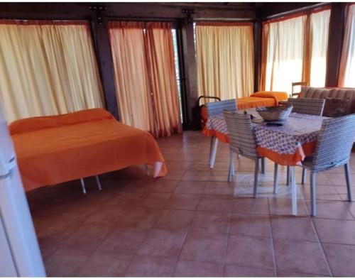 een kamer met een tafel en stoelen en een eetkamer bij villa da sogno in vetro in Castellammare del Golfo