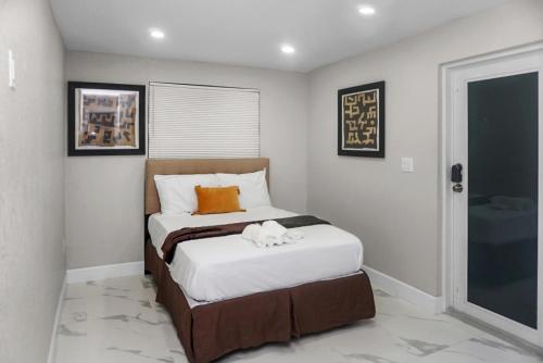 a small bedroom with a bed with white sheets at Miami Luxury Home Rental in Miami