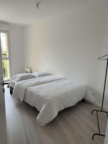 un lit blanc dans une chambre blanche avec une fenêtre dans l'établissement Appartement proche gare et centre-ville, à Angers