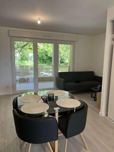 un salon avec une table, des chaises et un canapé dans l'établissement Appartement proche gare et centre-ville, à Angers