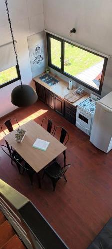 a kitchen with a table and chairs in a tiny house at Cabañas Abedul in Villa Meliquina