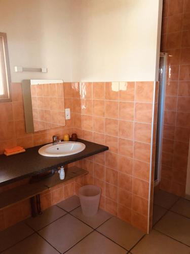 une salle de bain avec un lavabo et un miroir dans l'établissement Le Champ, à La Chaise-Dieu