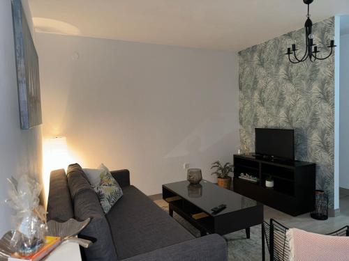 uma sala de estar com um sofá e uma televisão em Apartman Dukić em Okrug Gornji