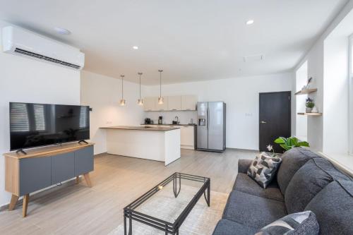 a living room with a couch and a kitchen at Willemstad Historic City Suites in Willemstad