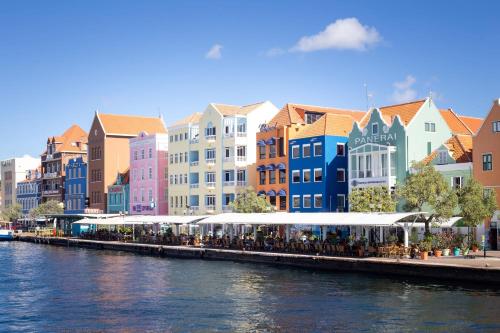 a group of people standing on aarf next to a river at Willemstad Historic City Suites in Willemstad