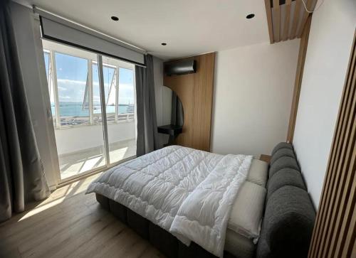 a bedroom with a bed and a large window at Yacht Concept Durrës Marina in Durrës