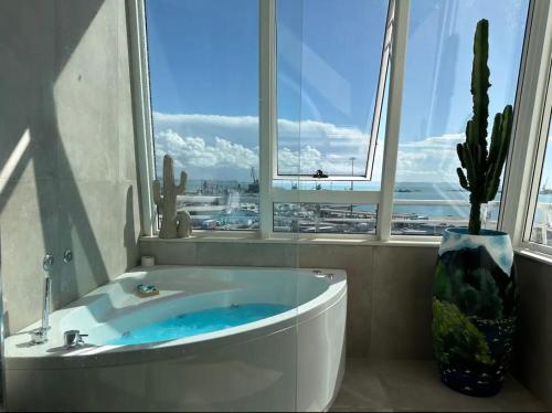 a bathroom with a bath tub with a window at Yacht Concept Durrës Marina in Durrës